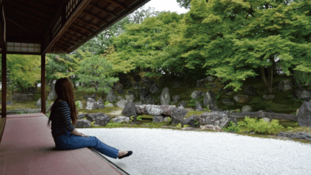 A solo traveler walking through a quiet street in Japan with traditional buildings at sunset
