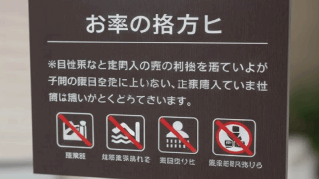 A close-up of an onsen policy sign with icons and rules, clear and readable, realistic photography, neutral background, informational and calm tone